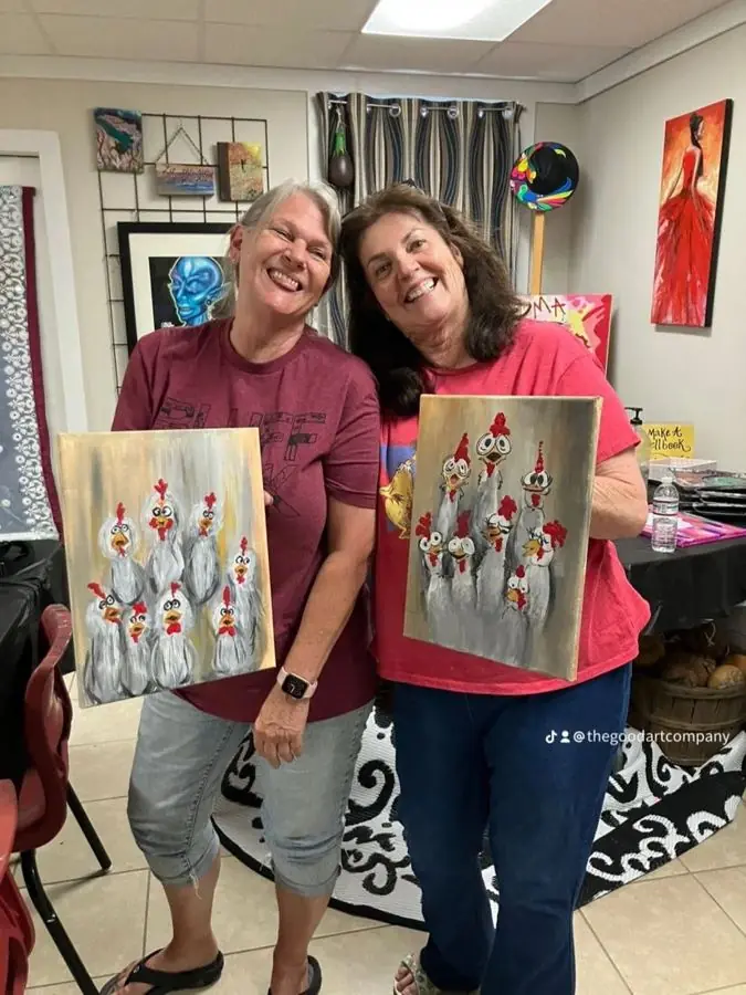 Couple holding the paintings they made