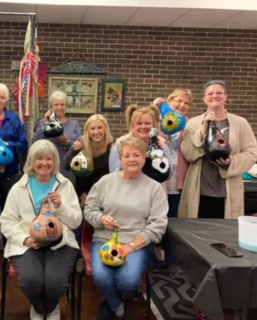 Friends showing off their painted gourds
